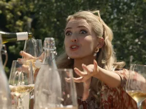A well-dressed young woman raises her hands, distressed, over a large number of wine glasses and bottles. A still from the new film 'The Birthday Trip' - and SWITCH is giving you the chance to win a double pass!